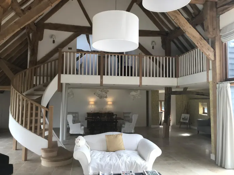 Barn conversion interior with curved staircase and mezzanine